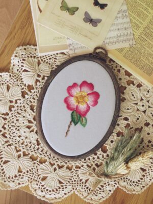 Ręcznie haftowany obraz z różą oprawiony w tamborek