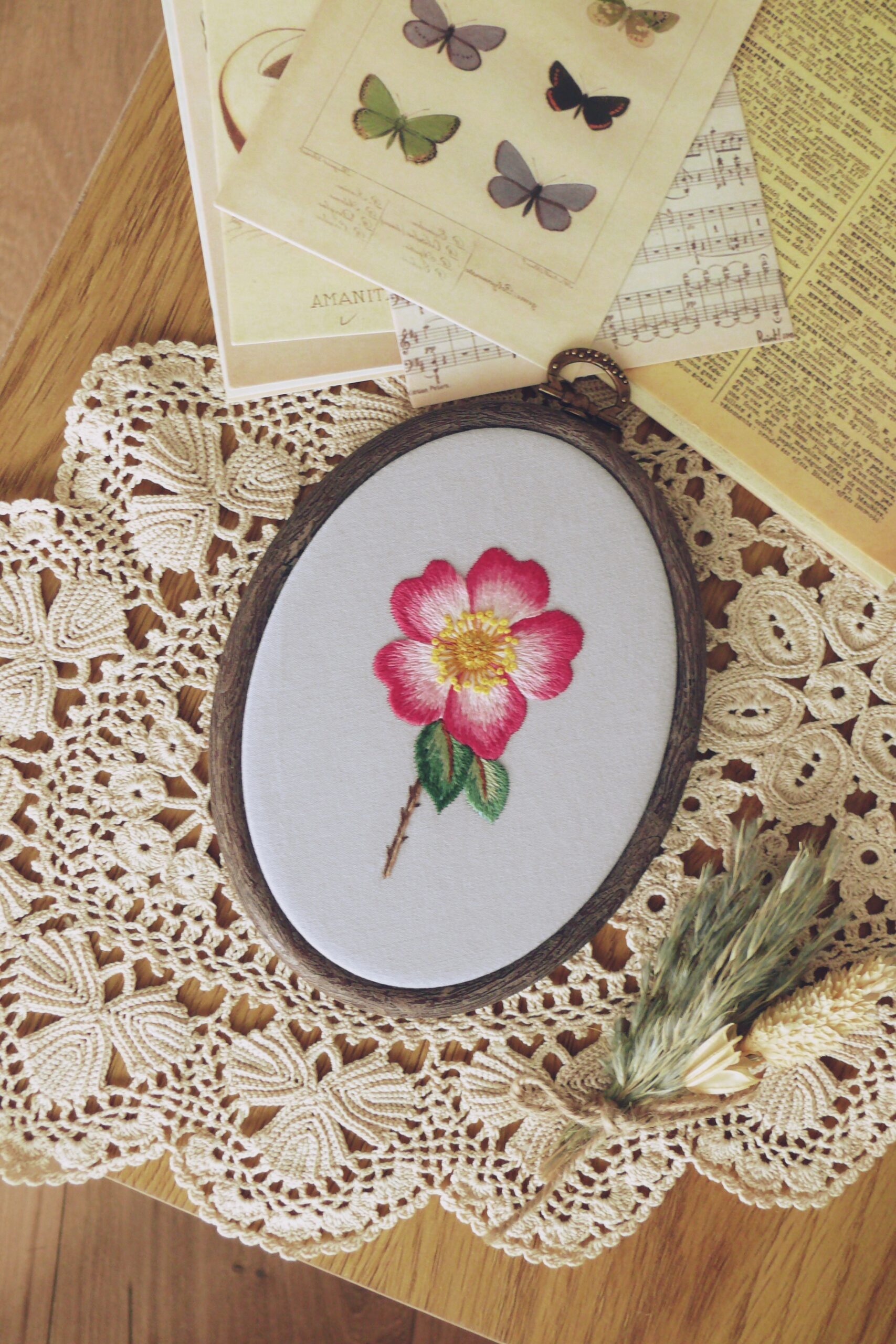 Ręcznie haftowany obraz z różą oprawiony w tamborek